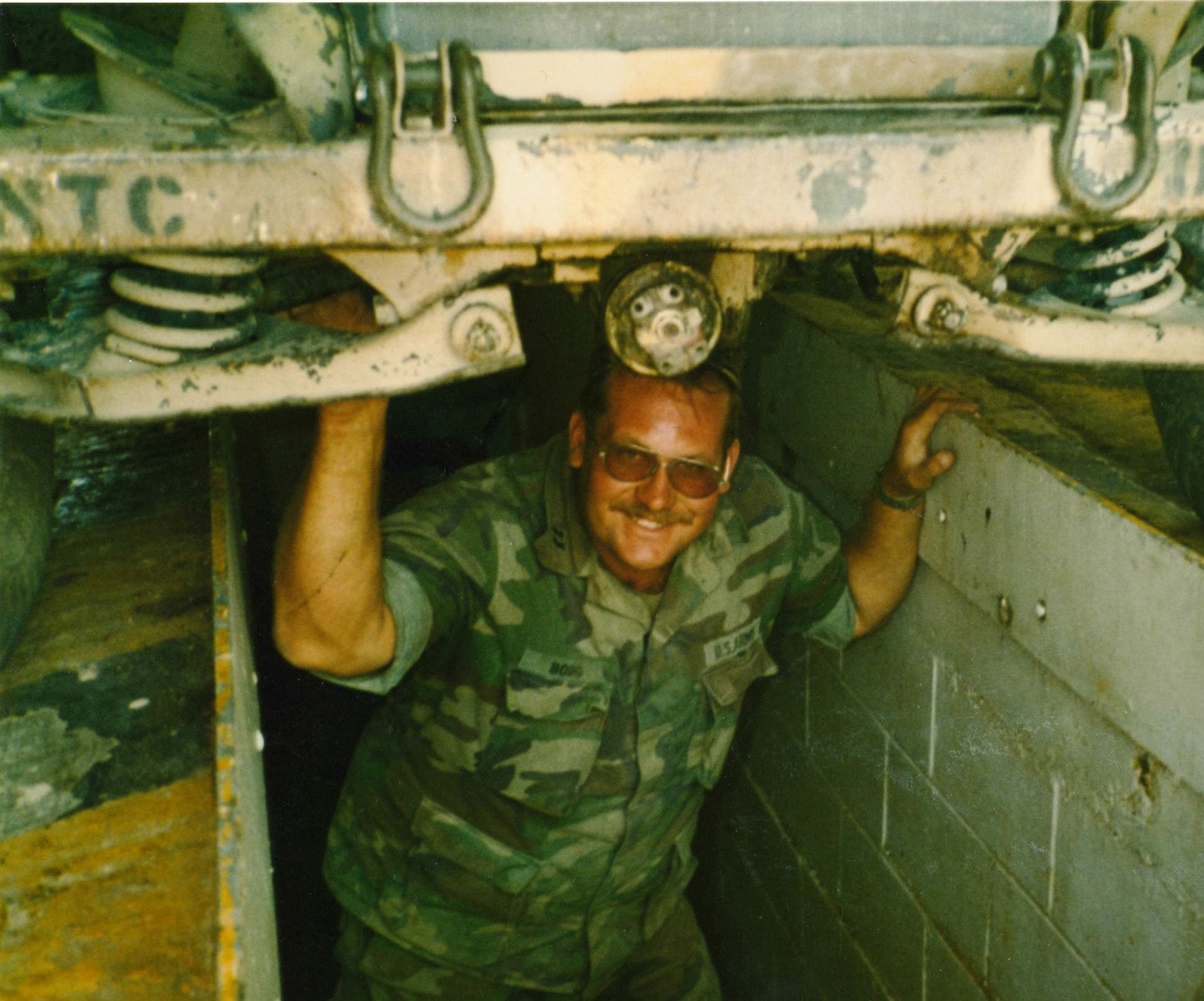 Axel Borg inspects the bottom of his jeep at the Army National Training Center in 1982.