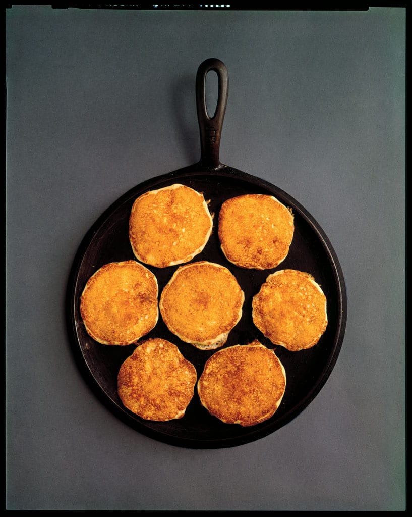Seven pancakes in a round cast iron pan, undated.
