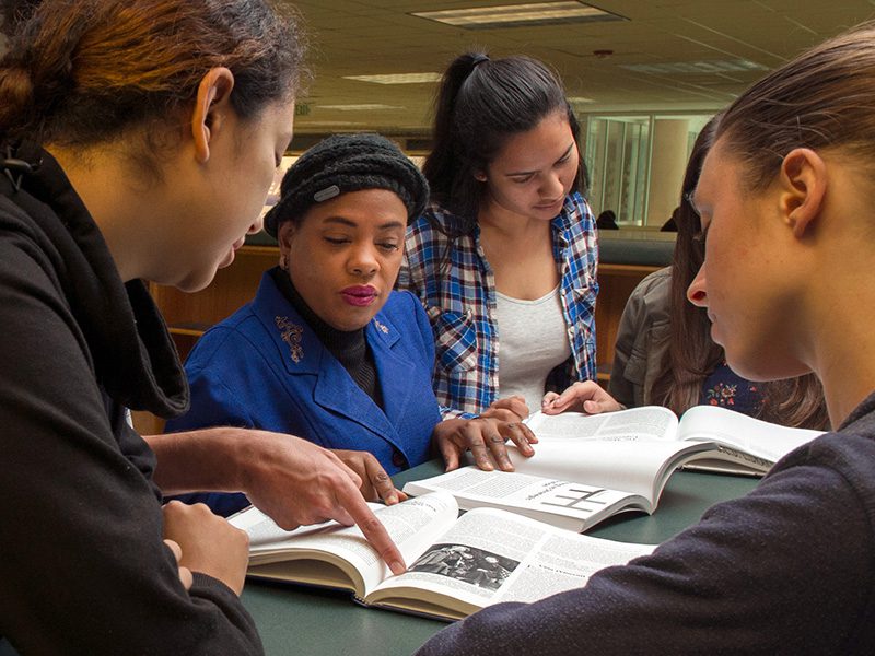 librarian looking at books with students