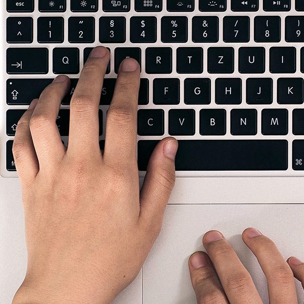 close up of hands typing on keyboard