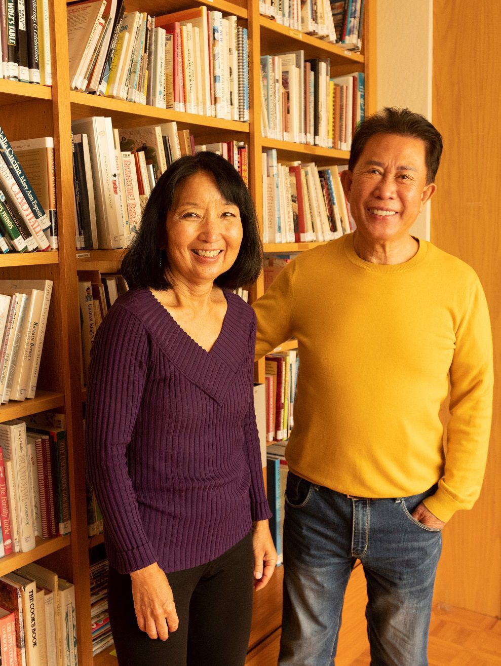 Susan and Martin Yan at their home in front of bookshelves holding many of the cookbooks donated to the UC Davis Library