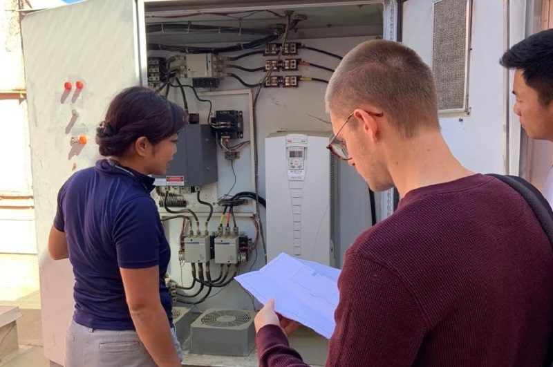 Three members of the UC Davis Facilities Energy & Engineering team look at part of the Shields Library HVAC system.