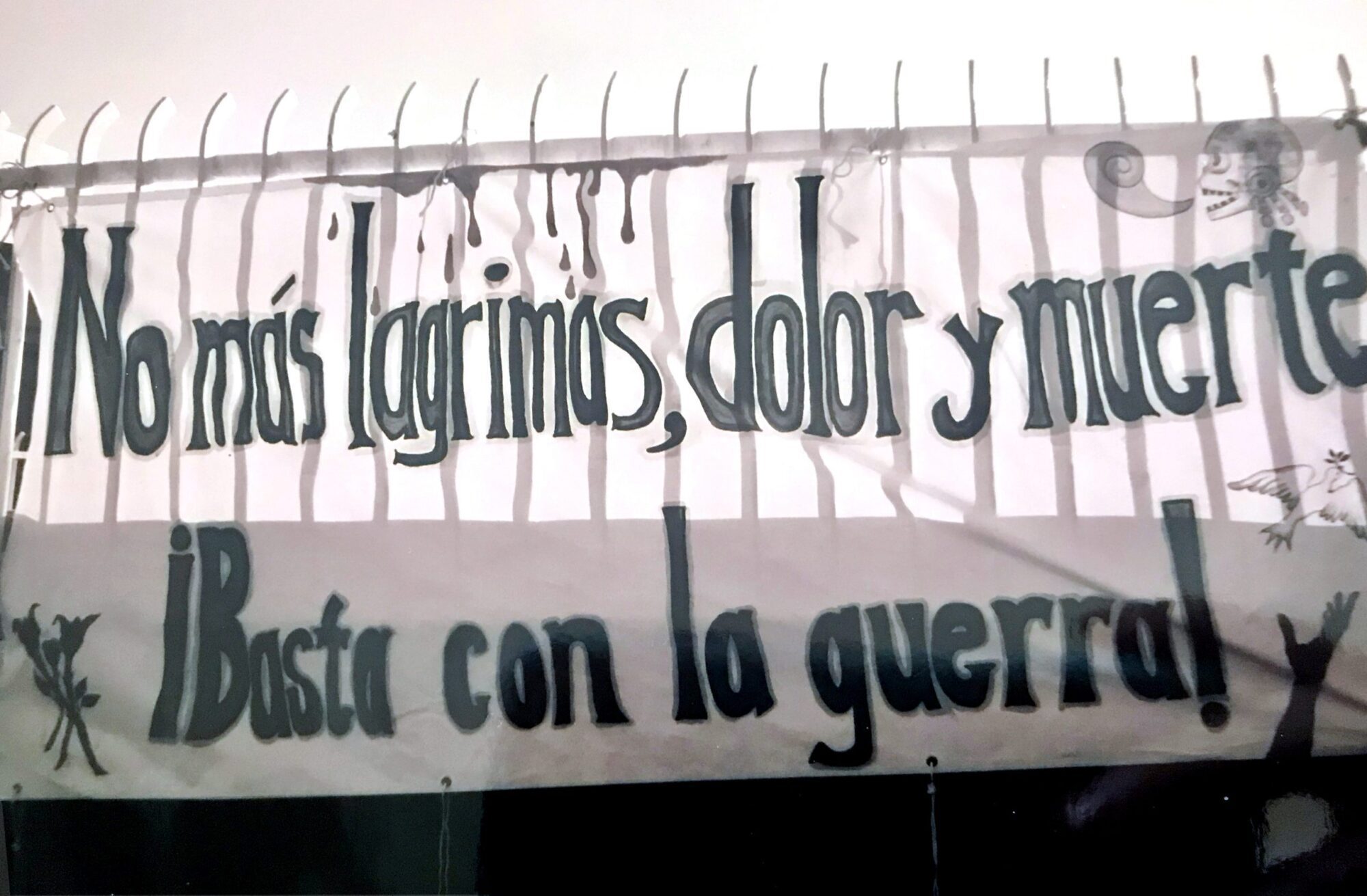 Banner reading "No más lágrimas, dolor y muerte. Basta con la guerra.