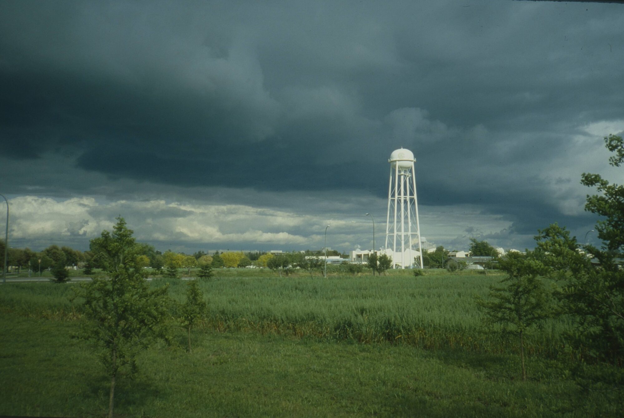 Water tower white against rain clouds