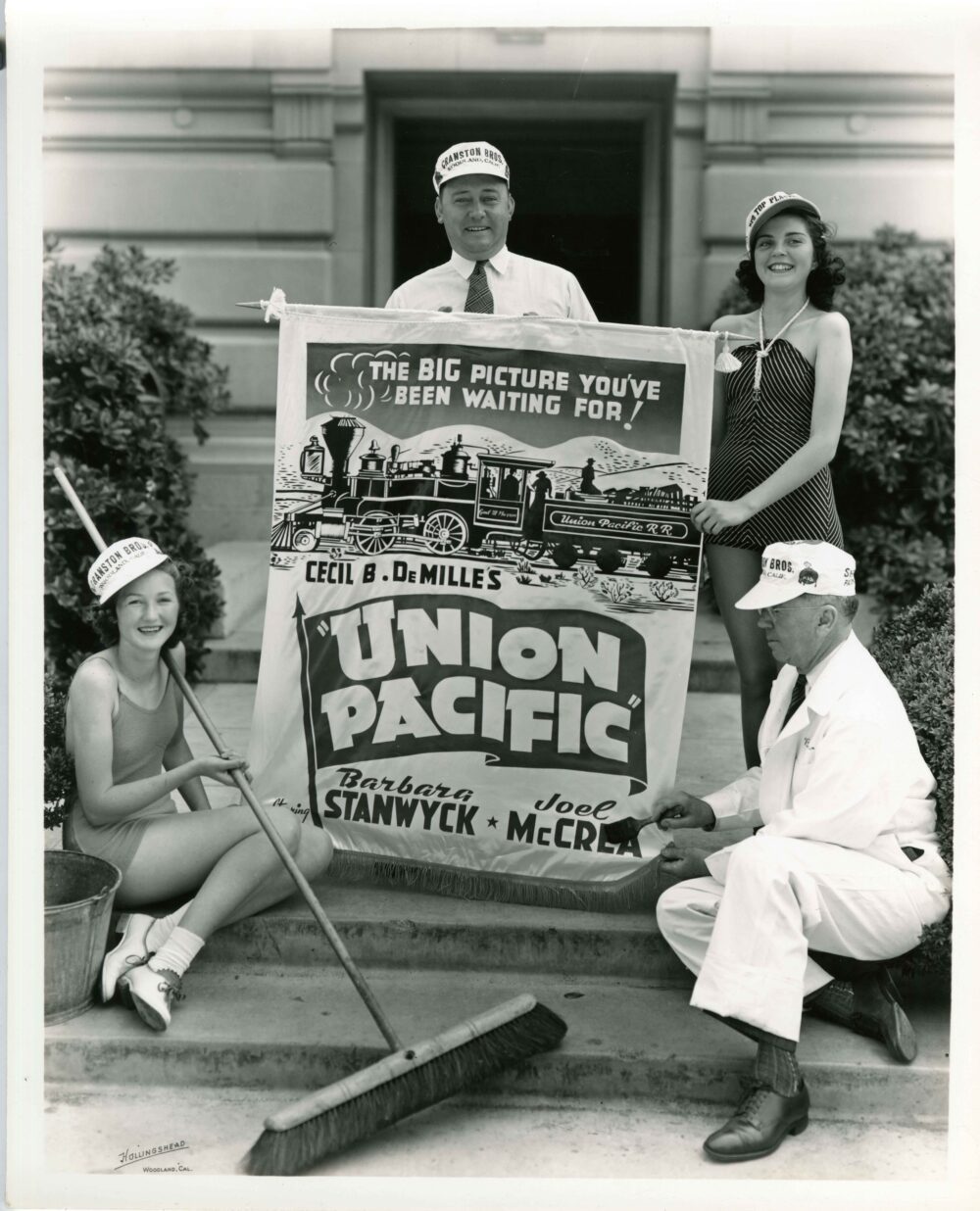 Two men and two women holding a movie poster