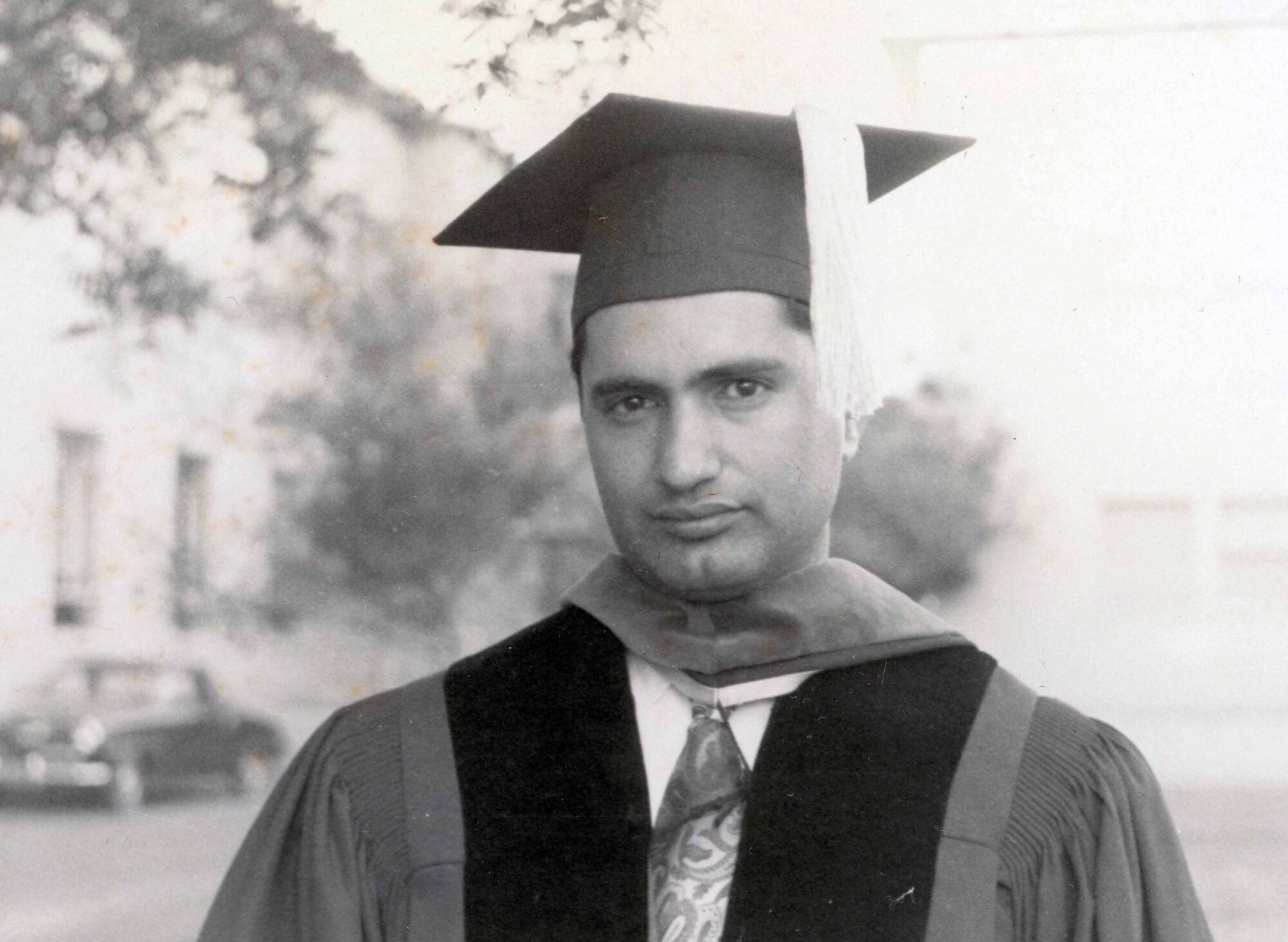 Black & white photo of a man in commencement gown