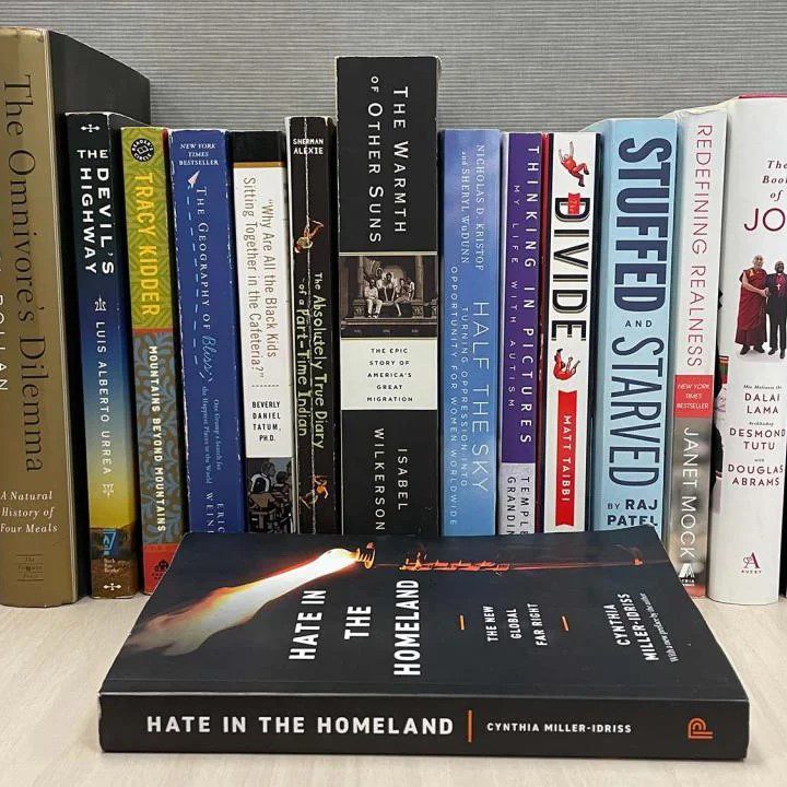 Shelf of books, with Hate in the Homeland on the table in front of the others