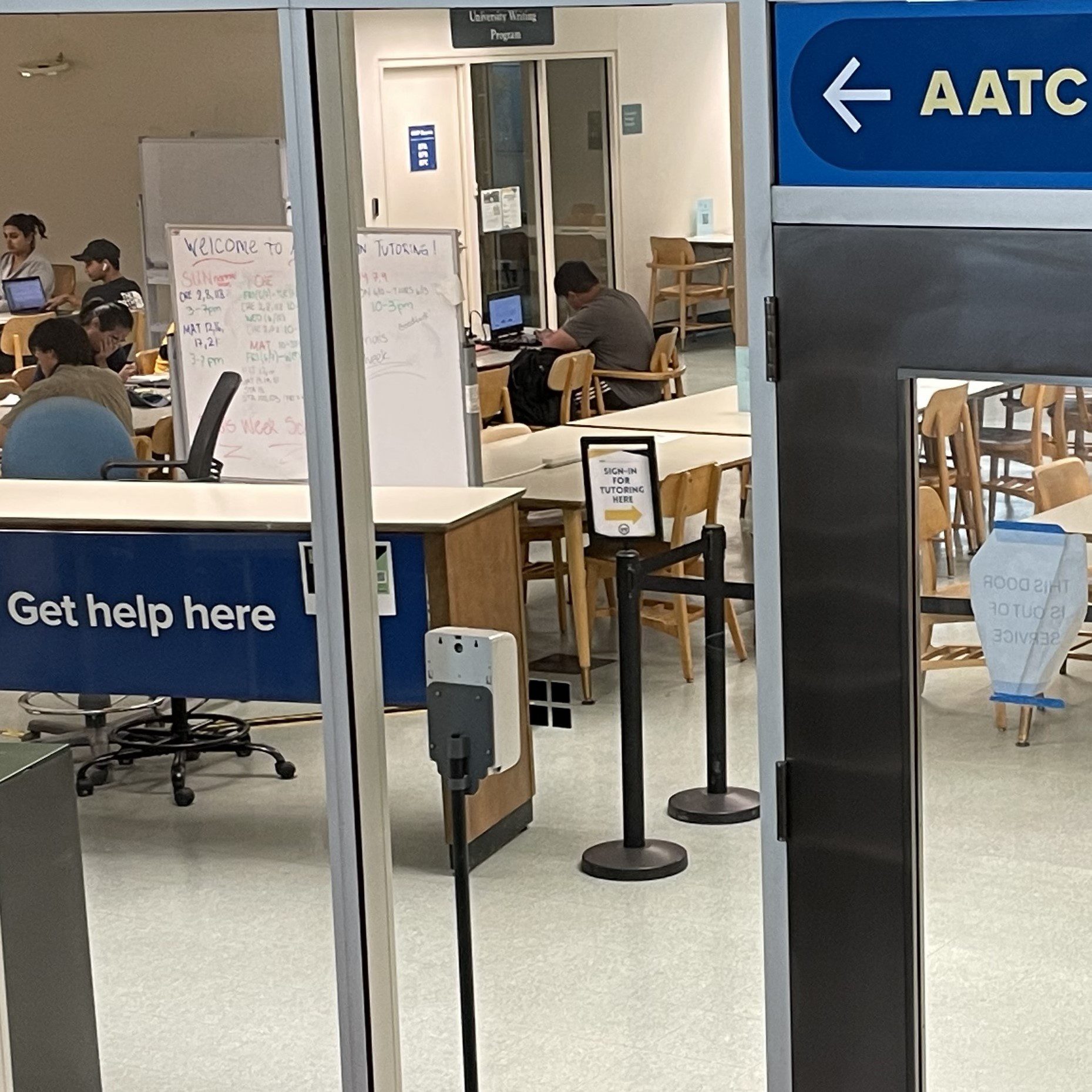 AATC drop-in tutoring entrance with "Get Help Here" sign and students studying the background