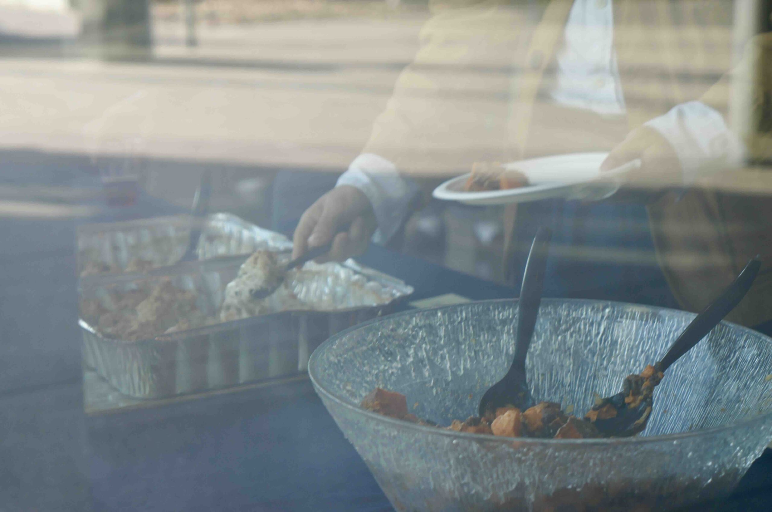 Guest hands reach for the community lunch from Chef Martin Draluck