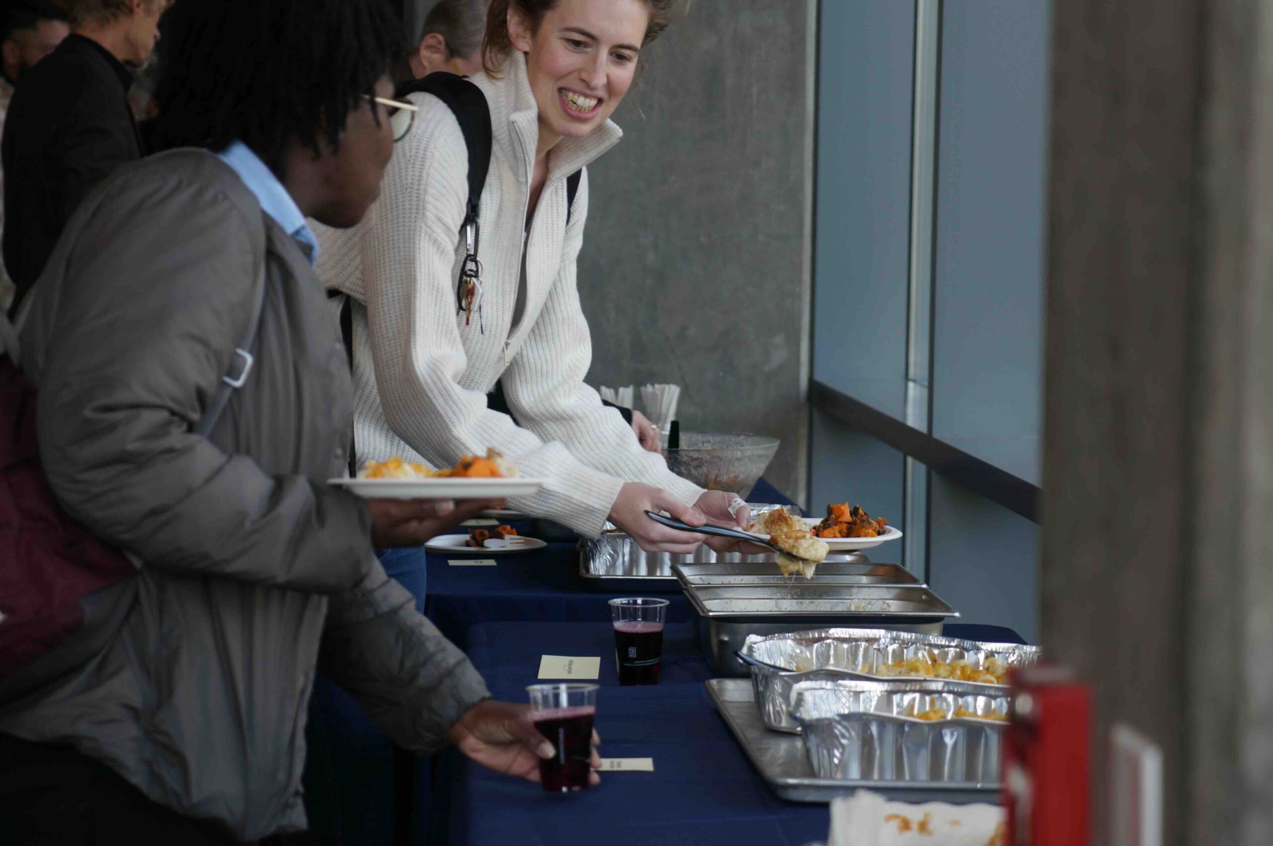 Guest hands reach for the community lunch from Chef Martin Draluck