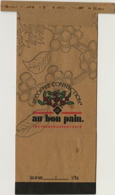 A brown coffee bag with faintly printed coffee berries in the background and the words “Coffee Connection®” over colored coffee berries floating above the words “at Au Bon Pain the French bakery cafe” with an empty “Sell by date” section at the bottom.