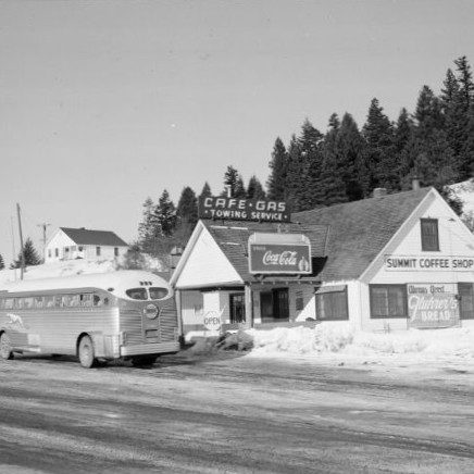 1940s Greyhound bus parked in front of building with sign reading "Summit Coffee Shop."