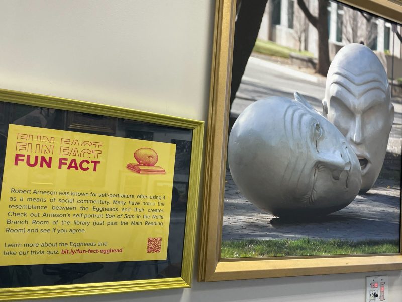 A framed Fun Fact on a bright yellow background, alongside a framed photo of the "Yin and Yang" Egghead sculpture.