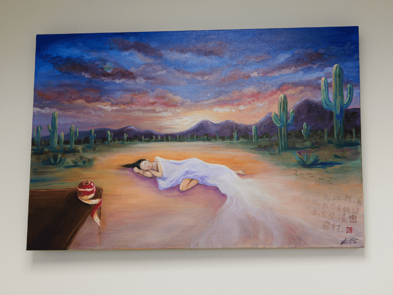 Oil on canvas of a lady in white robe appears to be sleeping in sunsetting desert sky.