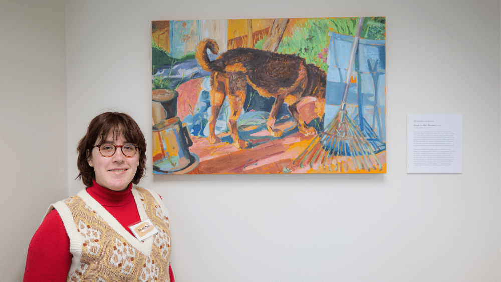 Sheridan Greene poses with her winning artwork, an oil and acrylic image of dog sniffing in a garden.