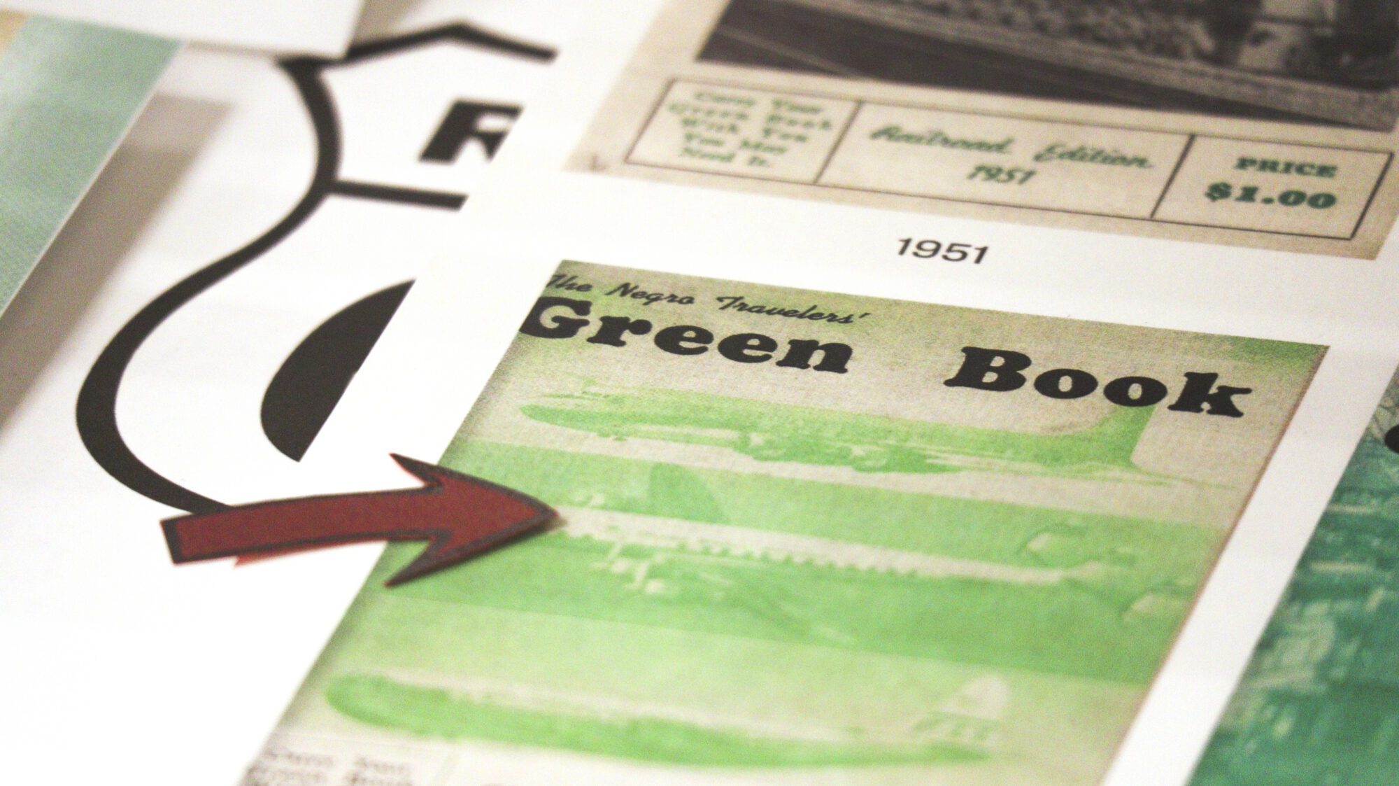 Exhibit item showing the 1953 cover of The Negro Travelers' Green Book with a red arrow pointing to it from the left side.