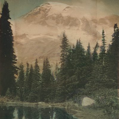 Colored image of a mountain, trees, and water in the foreground