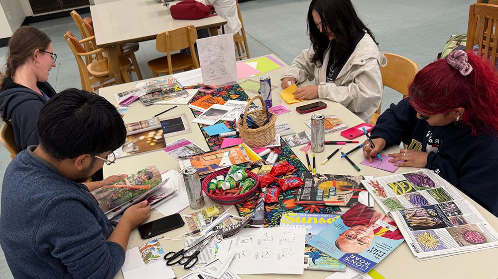 Students perusing magazines and crafting with paper, markers, and scissors at a Make-a-Zine event.