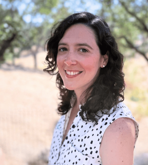 headshot of Sarah McClung with trees and yellow field in background.